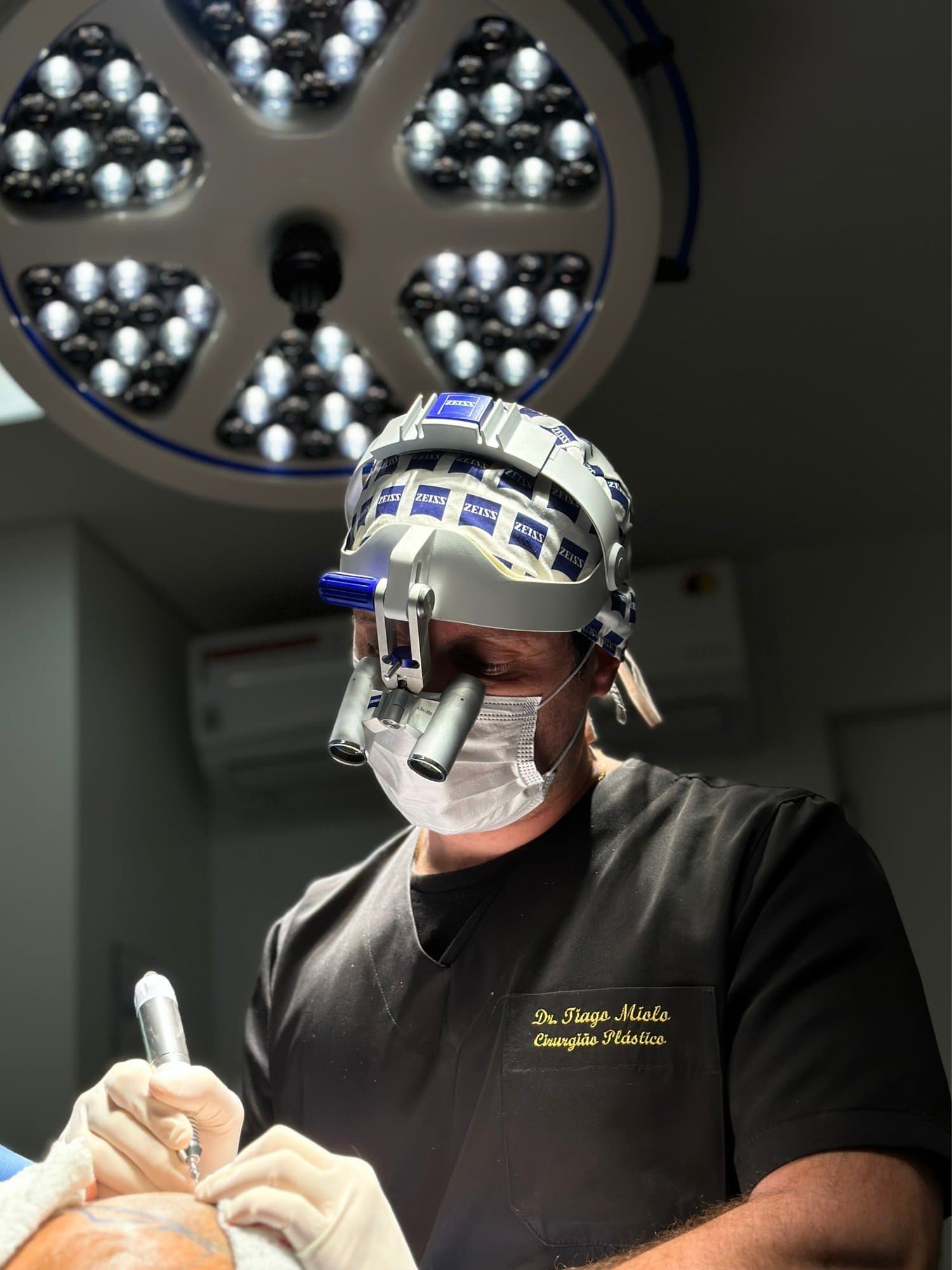 Dr. Tiago Miolo, cirujano plástico, durante un trasplante capilar con lupas quirúrgicas